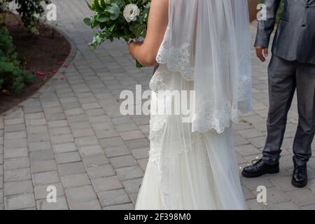 Mariée debout à l'extérieur avec bouquet Banque D'Images