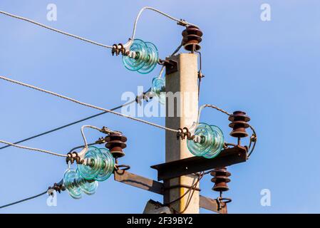 Pôle électrique contre le ciel bleu clair. Ligne d'alimentation triphasée à tourner. Banque D'Images
