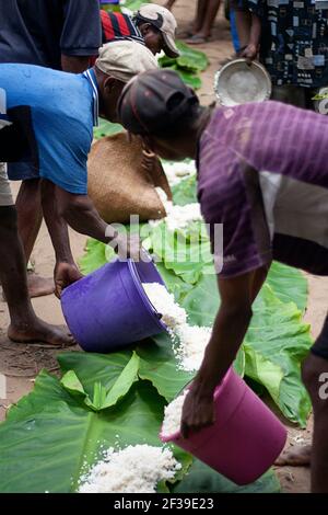 Préparer des feuilles de palmier sur le sol comme assiettes et nourriture, riz pour un festin à la cérémonie de Famadihana, ou le tournage des os, Maroansetra, Madagascar Banque D'Images