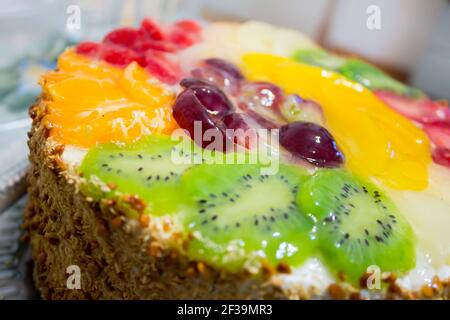 Gâteau coloré aux fruits en gelée avec kiwi, raisins, orange. Gros plan Banque D'Images