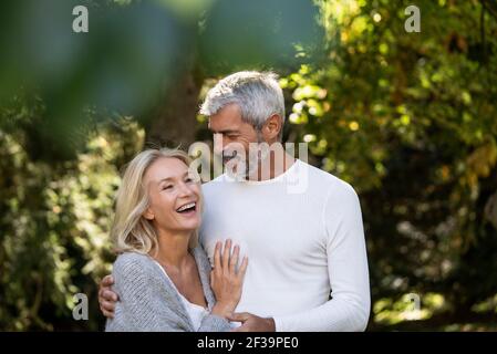 Couple d'âge mûr heureux embrassant dans l'arrière-cour Banque D'Images