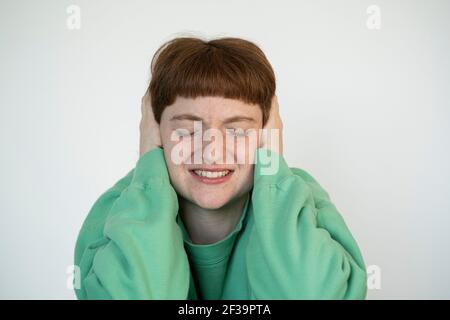 Gros plan de la femme stressée avec les yeux fermés couvrant les oreilles avec ses mains Banque D'Images