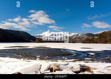 Lac Chambon en hiver, massif de Sancy en arrière-plan, Parc naturel régional des volcans d'Auvergne, Puy de Dôme, Auvergne, France Banque D'Images