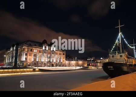 Turku, Finlande - 21 janvier 2016 : paysage urbain de Turku pendant la nuit d'hiver. Maisons et navires illuminés le long de la côte Banque D'Images