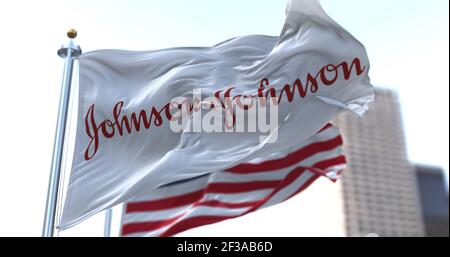 New Brunswick, NJ, États-Unis, 28 janvier 2021 : drapeau avec le logo Johnson & Johnson agitant dans le vent avec le drapeau américain. Johnson & Johnson a annoncé Banque D'Images