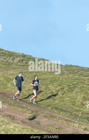 Image panoramique d'un coureur mâle et d'une femelle sur un sentier de Towan Head à Newquay, en Cornouailles. Banque D'Images