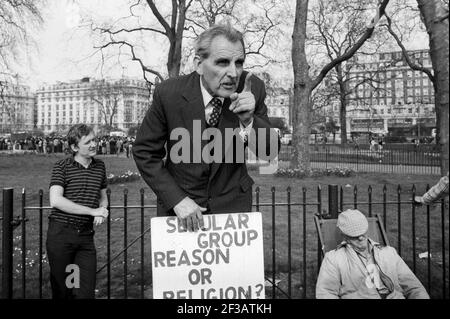 Homme âgé à Speakers Corner à Hyde Park Londres Angleterre Royaume-Uni portant le groupe laïque raison ou religion? écriteau photographié en 1984. Banque D'Images