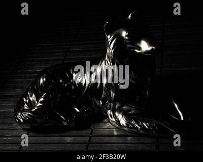 Statue en bronze d'un loup hurlant sur le côté du stand vue isolée sur fond blanc Banque D'Images