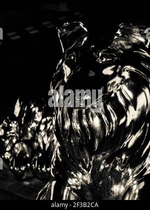 Statue en bronze d'un loup hurlant sur le côté du stand vue isolée sur fond blanc Banque D'Images