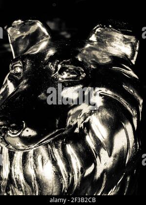 Statue en bronze d'un loup hurlant sur le côté du stand vue isolée sur fond blanc Banque D'Images