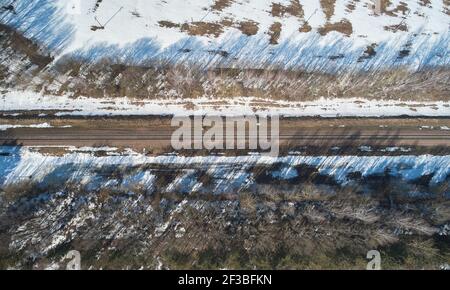 Ligne de chemin de fer vide au-dessus de la vue de drone sur la tache de neige d'hiver paysage Banque D'Images