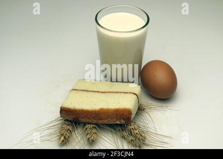 gâteau et blé mûr et oeuf et lait et atta sur fond blanc Banque D'Images