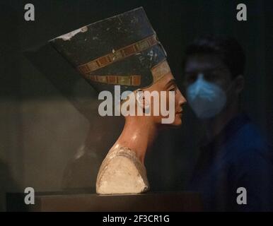Berlin, Allemagne. 16 mars 2021. Un homme portant un masque passe devant le buste de Nefertiti dans le Nouveau musée. Après le confinement de la couronne, certains musées ont rouvert leurs portes aux visiteurs aujourd'hui. Credit: Paul Zinken/dpa-Zentralbild/dpa/Alay Live News Banque D'Images