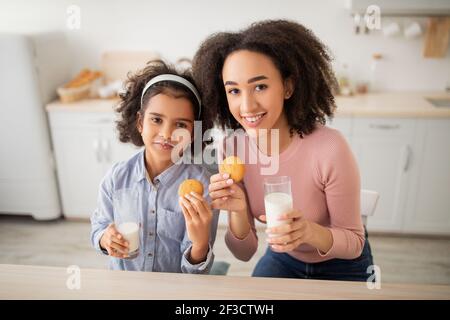 Mignon petite fille afro et son maman boire du lait Banque D'Images