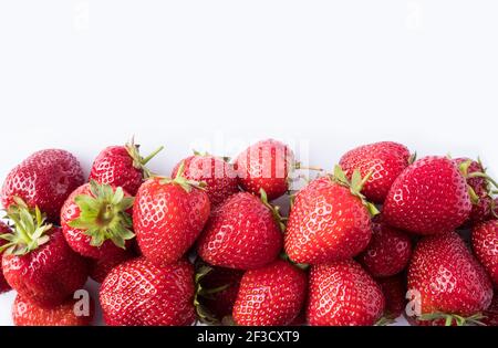 Fraises sur fond blanc. Gros plan sur les baies mûres. Fraises au bord de l'image avec espace de copie. Vue de dessus. Fond de baies rouges. Backgro Banque D'Images
