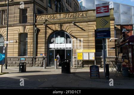 Entrée de la gare de Manchester Victoria avec passager entrant à la porte et panneau pour Intercity et Metrolink, Greater Manchester, Royaume-Uni Banque D'Images