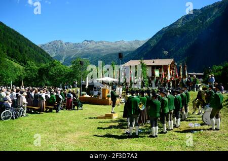 Feichten, Autriche - 22 juin 2014 : personnes inconnues en costume traditionnel dans une masse de campagne dans la vallée de Kaunertal dans le Tyrol du Nord Banque D'Images