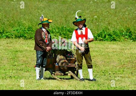 Feichten, Autriche - 22 juin 2014 : deux hommes non identifiés en costume traditionnel avec des armes à feu en salant par masse sur le terrain au Tyrol Banque D'Images