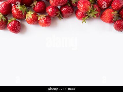 Fraises sur fond blanc. Gros plan sur les baies mûres. Fraises au bord de l'image avec espace de copie. Vue de dessus. Fond de baies rouges. Backgro Banque D'Images