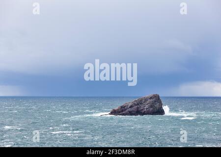 Île Rocky en face de Cap Frehel avec des nuages de pluie. Bretagne, France Banque D'Images