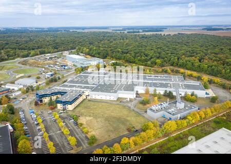 Vue de drone sur le hall de production dans la zone industrielle. Entrepôts modernes ou bâtiments de production entourés d'arbres. Industrie, transport et logistique. Banque D'Images