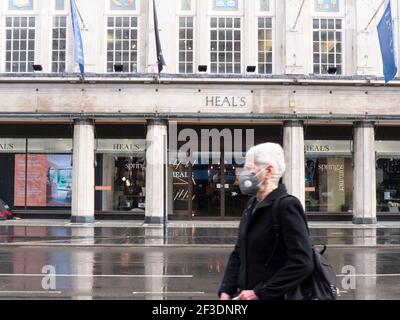 Une personne portant un masque d'epi passe devant le magasin de meubles de Heal pendant Angleterre Covid-19 blocage du coronavirus Banque D'Images