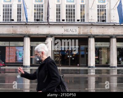Une personne portant un masque d'epi passe devant le magasin de meubles de Heal pendant Angleterre Covid-19 blocage du coronavirus Banque D'Images