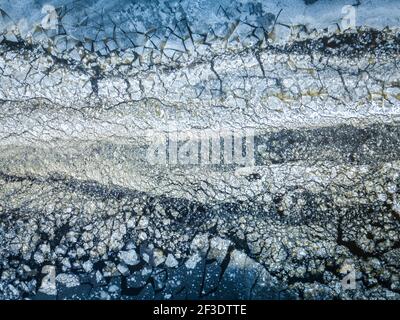 Vue de haut en bas de divers flotteurs de glace sur la surface de l'eau de drone. Arrière-plan naturel d'hiver abstrait. Banque D'Images