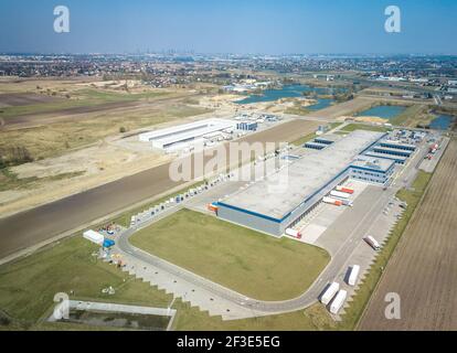 Vue de drone sur l'entrepôt moderne dans le parc logistique de l'aéroport de Varsovie. Camions amarrés à un grand hall. Concept de transport et de logistique. Banque D'Images