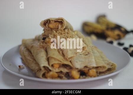 Crêpes ou crêpes plantain faites maison avec mélange de raisins de coco plantain au milieu. Prise de vue sur fond blanc. Banque D'Images