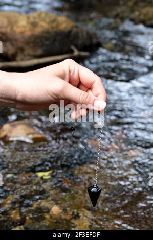 Travaillez avec un bijou de pendule noir en onyx à l'avant d'une rivière Banque D'Images