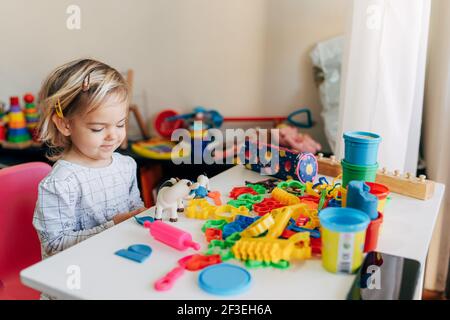 Budva, Monténégro - 17 mars 2021 : une fille joue de la plasticine à la table. Banque D'Images