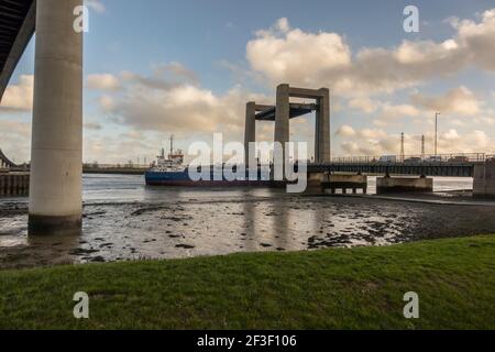 Bateau passant par le pont Kingsferry qui relie l'île de Shepey et le Kent à travers le Swale. De sous le nouveau pont de traversée de Shepey Banque D'Images