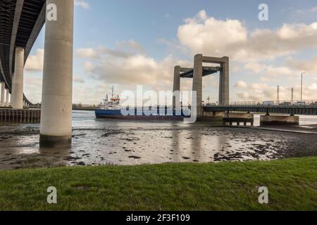 Bateau passant par le pont Kingsferry qui relie l'île de Shepey et le Kent à travers le Swale. De sous le nouveau pont de traversée de Shepey Banque D'Images