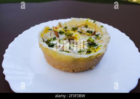 Traditionnel et authentique plat sucré indien de style halwai appelé Ghevar ou ghewar, dessert indien préparé et mangé pendant des festivals comme Holi, diwali Banque D'Images