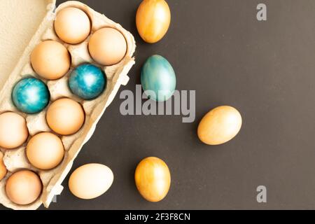 Œufs de Pâques, fleurs sur fond sombre. Flat lay, vue de dessus, espace de copie. Le jour de Pâques. Banque D'Images