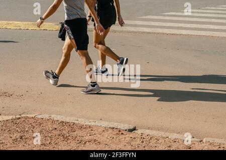 Les pieds de la course à pied sur la route près de la chaussure. Concept de welness d'entraînement de jogging de remise en forme de lever de soleil de personnes Banque D'Images