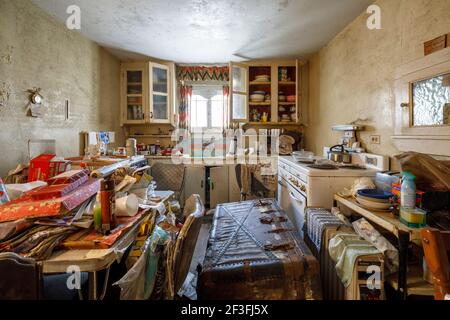 Une cuisine très désordonnée à l'intérieur d'une maison abandonnée. Banque D'Images