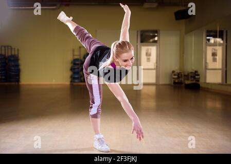 Un jeune entraîneur sportif danse dans la salle de sport. Banque D'Images