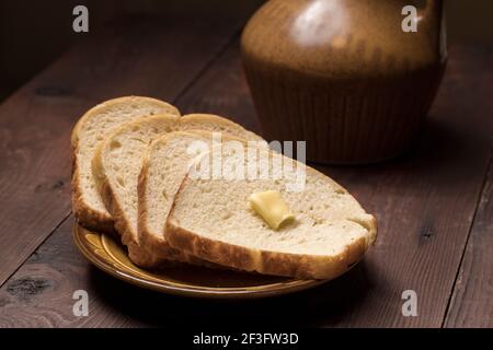 Un gros plan de tranches de pain et de beurre faits maison sur une assiette. Banque D'Images