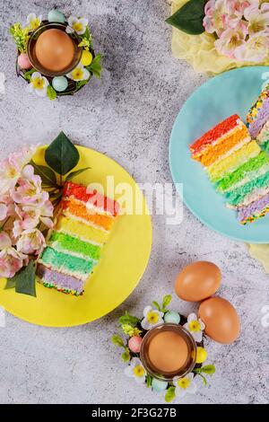 Gâteau coloré coupé avec des œufs bruns pour Pâques sur fond de bois. Banque D'Images