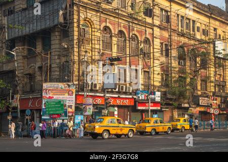 Taxi jaune attendant les passagers au croisement de la route de la ville avec Vue sur l'ancien bâtiment du gouvernement à Kolkata India Banque D'Images