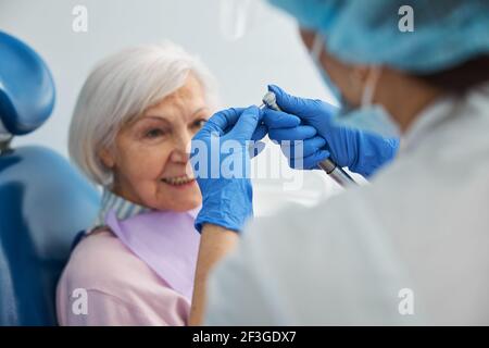 Femme agitée regardant un médecin changer d'exercice dentaire Banque D'Images