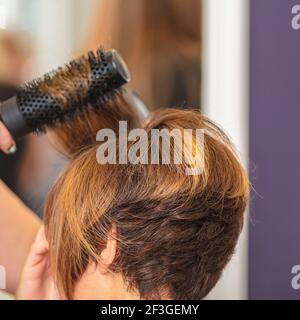 Femme fait les cheveux par peigne dans le salon de beauté. Coupe courte Banque D'Images