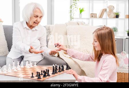 Fille jouant aux échecs avec grand-mère