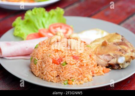 Cuisine thaïlandaise - riz frit avec un mélange de légumes et de noix de cajou, servir avec du jambon, du poulet frit et de l'eeg (appelé riz américain ou frit américain Kaw Pad) Banque D'Images