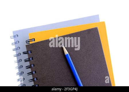 Pile de carnets ou de copybooks avec crayon sur le dessus - arrière-plan blanc Banque D'Images