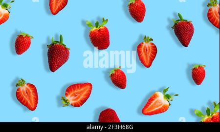 Différentes fraises mûres et tranches de fraises isolées sur fond bleu. Bannière. Banque D'Images