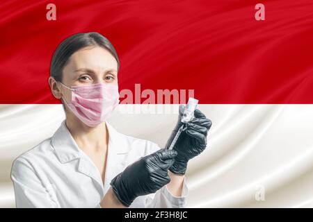 La jeune fille prépare la vaccination contre le fond du drapeau indonésien. Concept de vaccination Indonésie. Banque D'Images