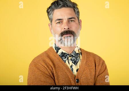 Photo d'un homme mature, isolé sur fond de mur jaune Banque D'Images